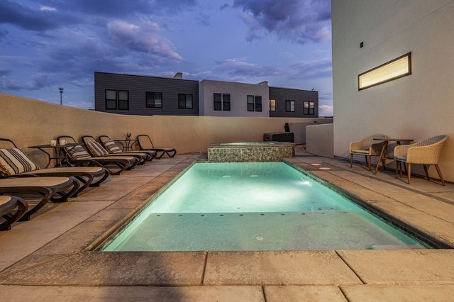 Private heated pool and spa with lounge chairs at dusk
