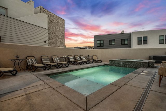 Lit private pool with lounge chairs at sunset