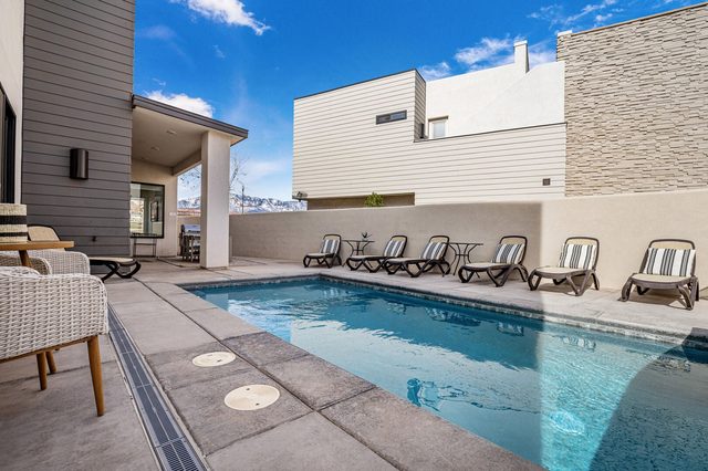 Private pool with lounge chairs along the privacy wall