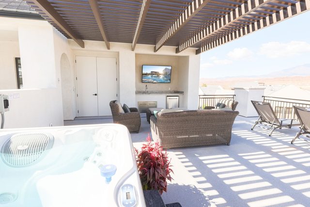 Rooftop private hot tub beside lounge seating and outdoor TV