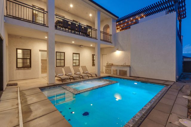 Private pool and spa glowing at dusk in the home courtyard