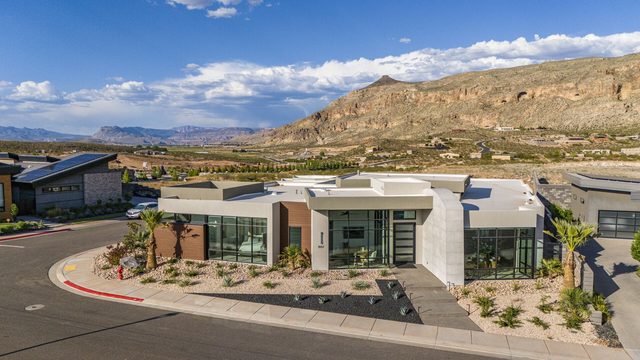 Front exterior of Copper Rock 3557 with desert landscaping and cliffs