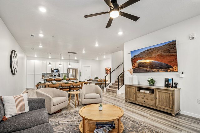 Living room with TV console, sectional and open kitchen view