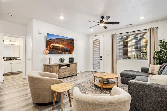 Living room seating around round coffee table with TV wall
