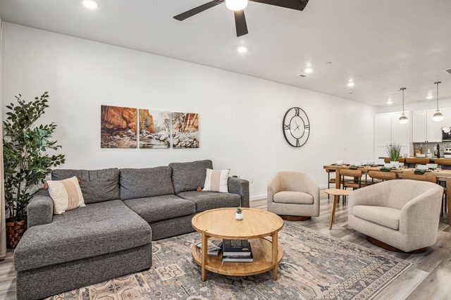 Main living area with gray sectional and dining table behind