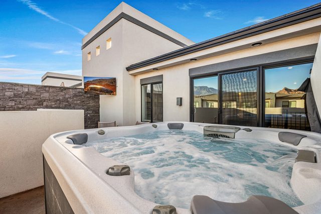 Rooftop hot tub beside sliding doors to the home