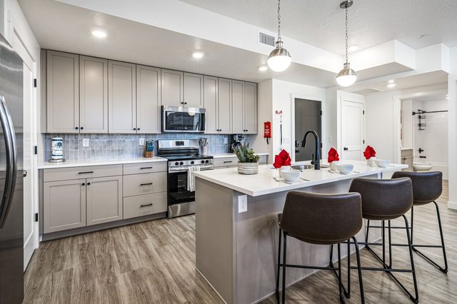 Kitchen with island bar seating and stainless steel range