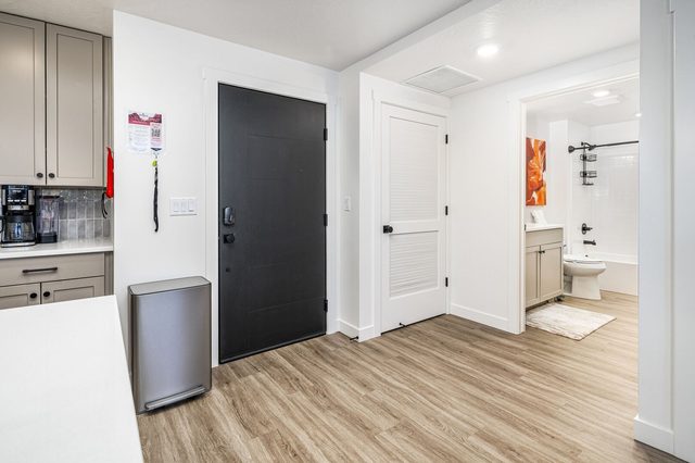 Entry hallway with front door and view into the bathroom