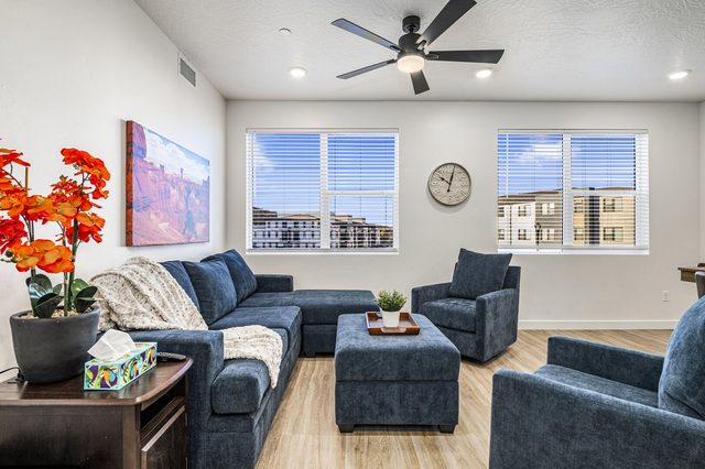 Living room with blue sectional sofa, armchairs and ottoman