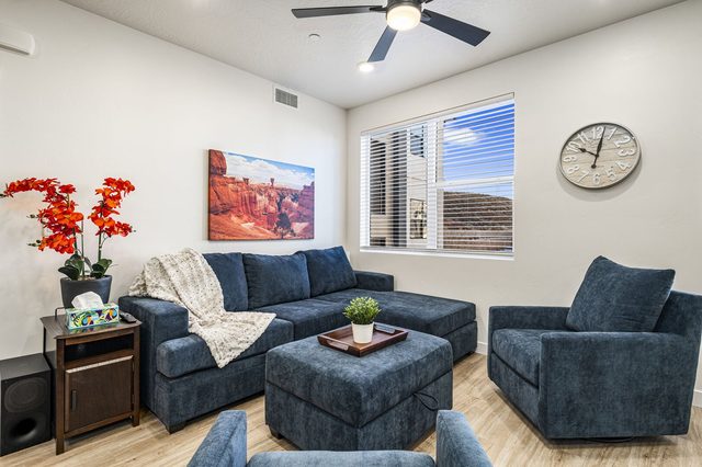 Living room with blue sectional, armchair and large windows