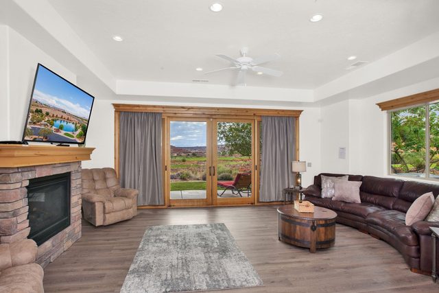 Living room with stone fireplace, sectional sofa and patio sliding doors