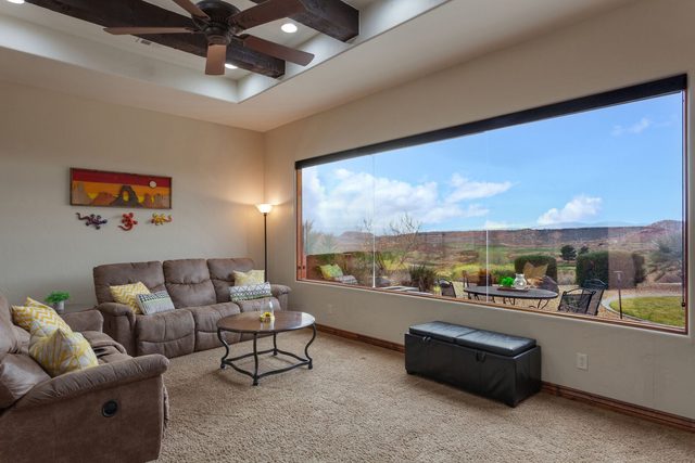 Living room with sectional seating and wide golf-view window at Coral Ridge 1919