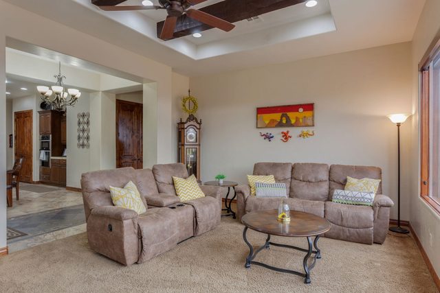 Living room recliners and coffee table opening to the kitchen at Coral Ridge 1919