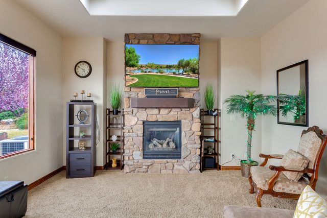 Stone gas fireplace with mounted TV in the living room