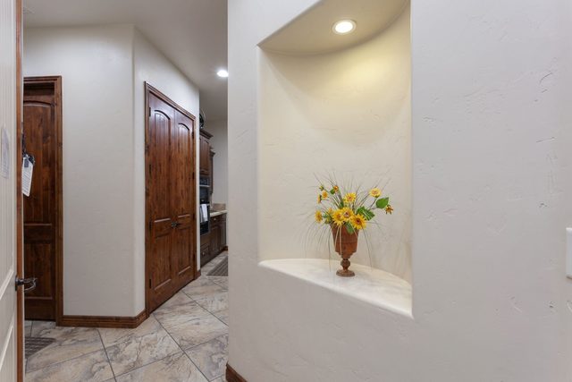 Entry hallway with lit wall niche and tile floors