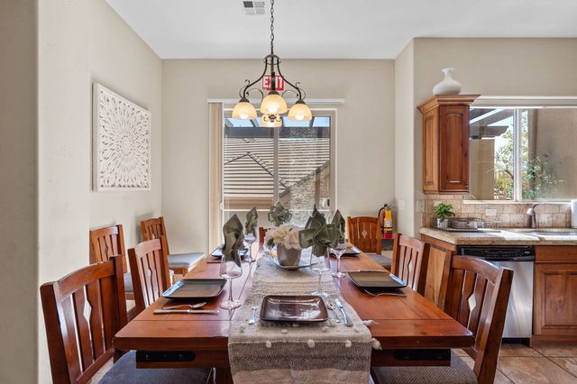 Dining table set for eight under a wrought iron chandelier