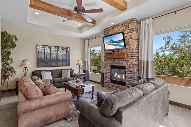 Living room with stone fireplace, wall-mounted TV and two sofas