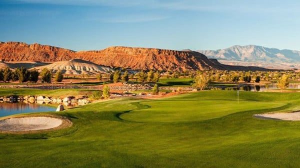 Golf fairway and bunker with red cliffs behind
