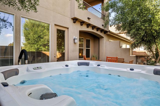 Private hot tub on the back patio beside the home