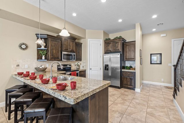 Kitchen island with bar stools and stainless refrigerator