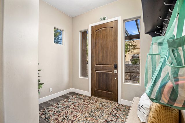 Front entry foyer with wood door and area rug