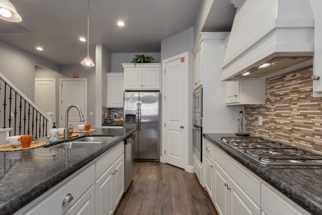 Kitchen gas cooktop, tile backsplash and stainless refrigerator