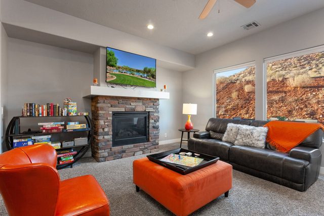 Living room with stone gas fireplace, leather sofa and TV
