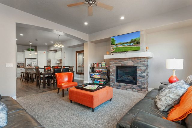 Great room with fireplace, orange ottoman and dining area beyond