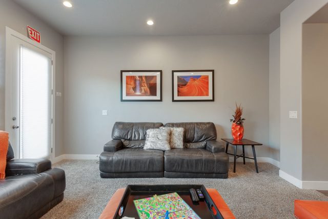 Leather sofa and loveseat around a game-topped ottoman