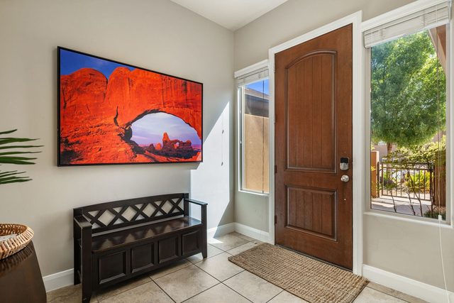Front door entry with bench and red rock art at Coral Ridge 2087