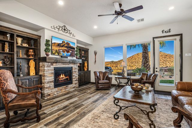 Living room with stone fireplace, TV and leather seating