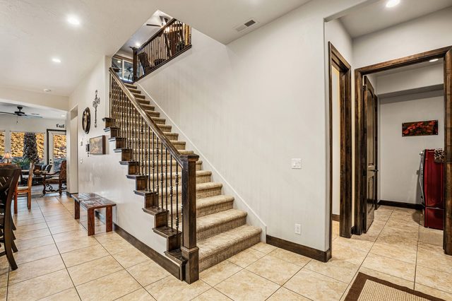 Entry hall and carpeted staircase leading to the upper level