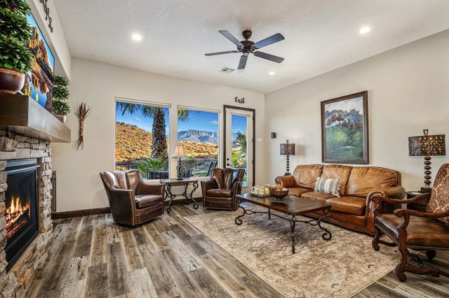 Living room with gas fireplace, leather sofa and patio door