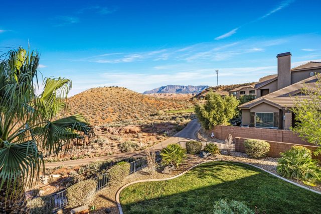 Backyard lawn with views of desert hills and neighboring homes