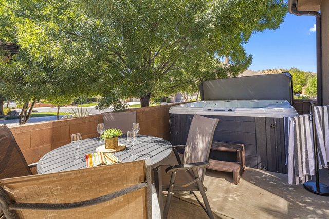 Patio dining set beside the private hot tub under trees