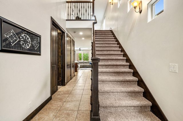 Hallway and carpeted staircase leading to the upstairs loft