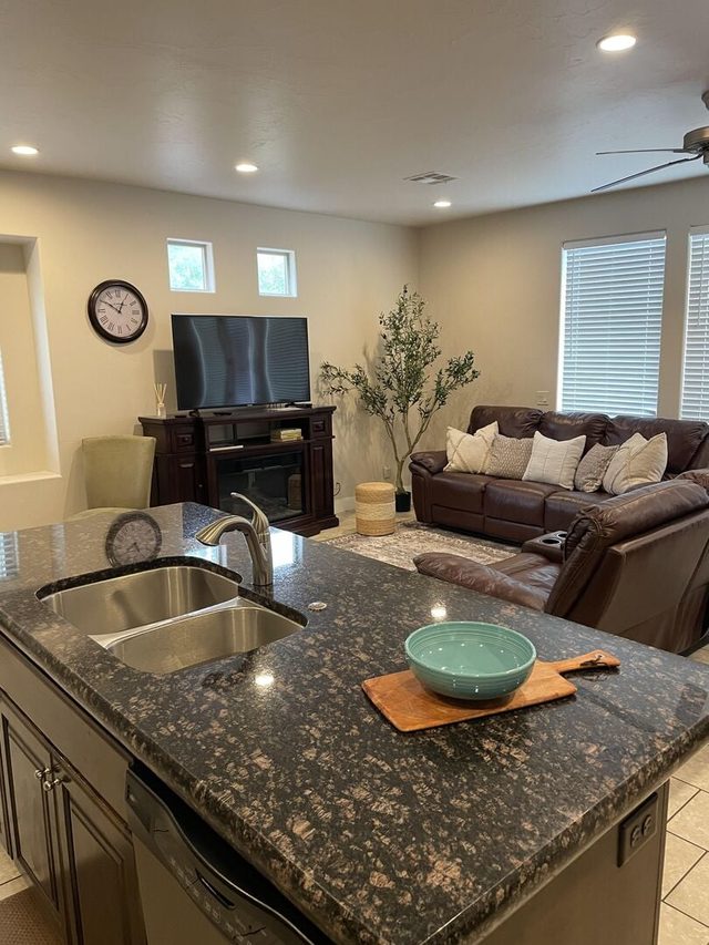 Granite kitchen island overlooking the living room and TV