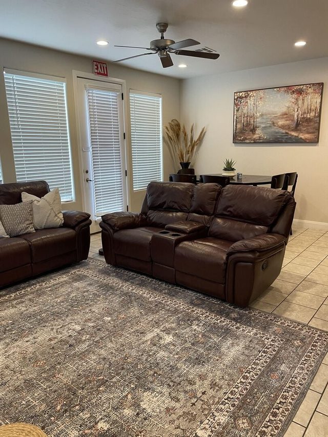 Leather reclining sofas on a large rug near patio doors