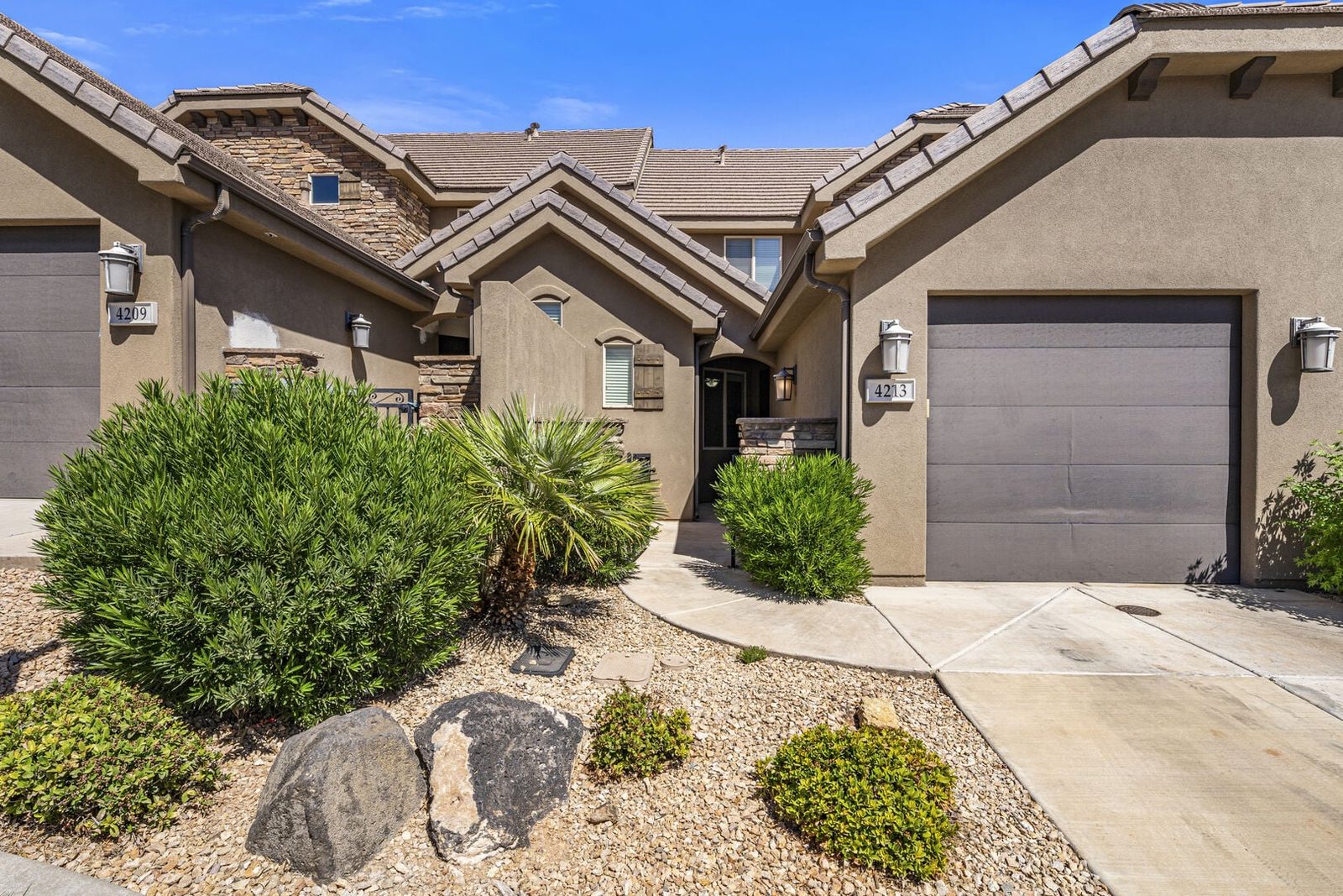 Front exterior and garage of Coral Ridge 4213 townhome with desert landscaping