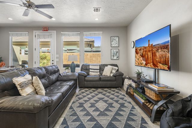Living room with leather sectional and wall-mounted TV at Coral Ridge 4213