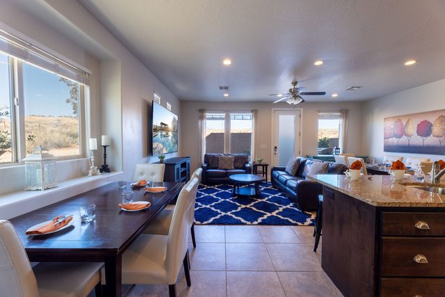 Open great room with dining table, kitchen island and sofas