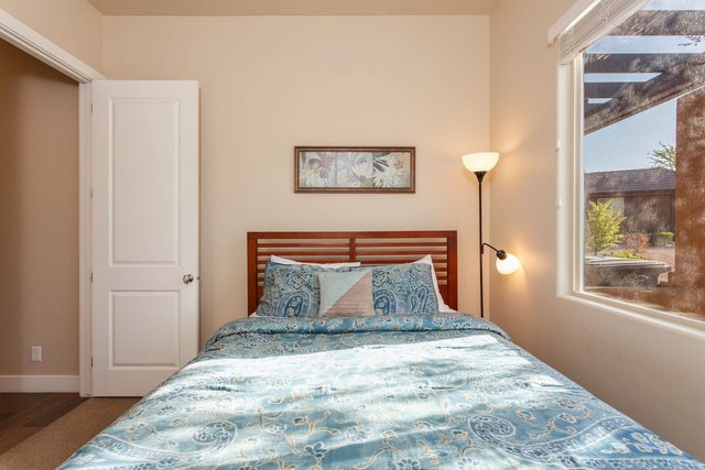 Queen bedroom with wood headboard and window light