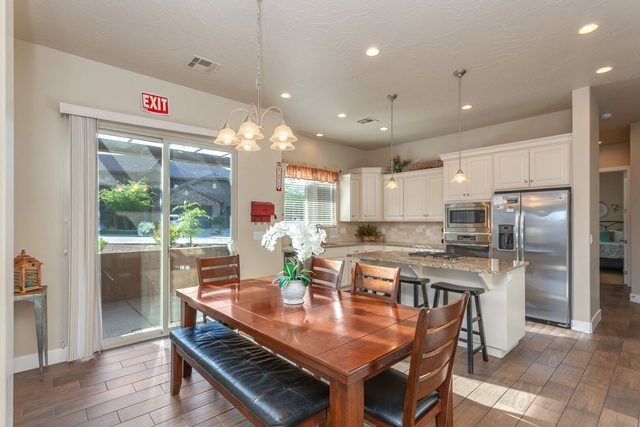 Dining table with bench seating beside kitchen and patio door