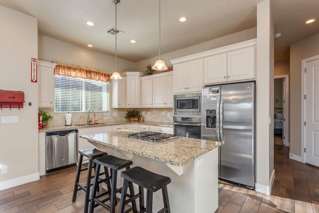 White kitchen with granite island and bar stools at Coral Ridge 4246
