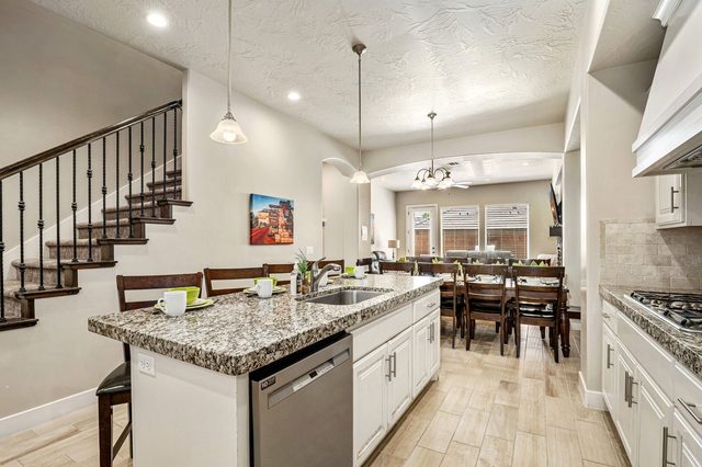 Kitchen island with sink and bar seating toward the dining room