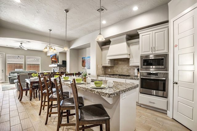 Granite kitchen island with bar stools and dining table beyond