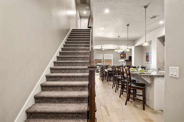 Carpeted staircase beside the kitchen bar seating