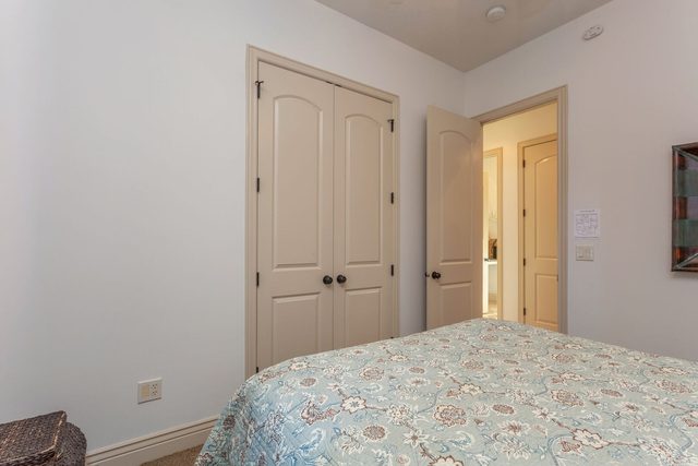 Second bedroom showing double closet doors and queen bed