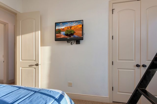 Wall-mounted Roku TV opposite the bed in the third bedroom
