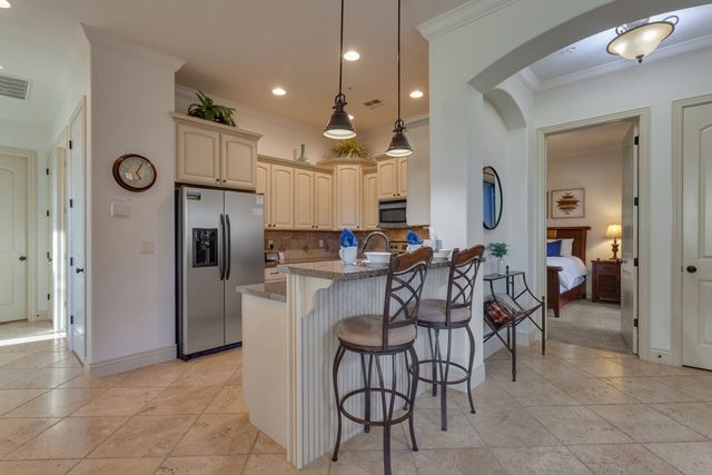 Kitchen breakfast bar with stools and stainless refrigerator